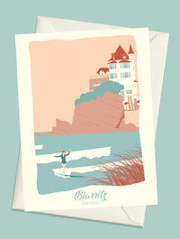 Carte postale illustrée intitulée “Biarritz, La Surfeuse” par Julie Roubergue, représentant la Villa Belza en fond et une surfeuse en premier plan dans les tons pastel